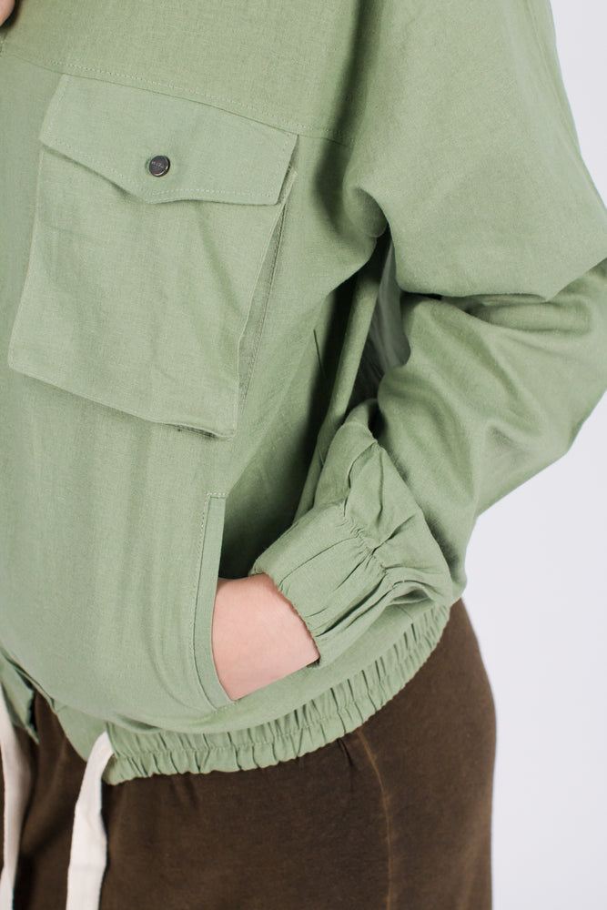 Muzca Imogen Linen Jacket In Green Modest Loose Collarless Jacket with Zipper, Chest Pockets, and Drawstring in Linen